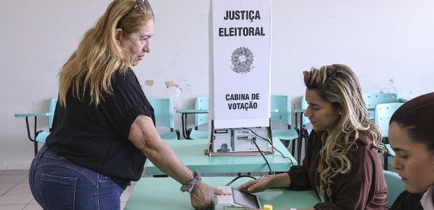 Eleitora sendo identificada por biometria em cabine de votação da Justiça Eleitoral