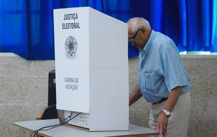 Idoso votando em cabine da Justiça Eleitoral